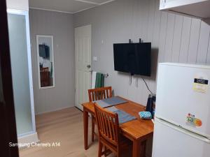 a kitchen with a table and a white refrigerator at The Flat 28B on Ordnance in Lithgow