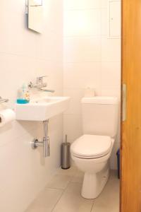 a white bathroom with a toilet and a sink at Christiania Central Nendaz in Nendaz +22 photos