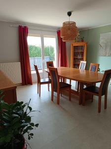 a dining room with a wooden table and chairs at Maison grande terrasse Poligny in Poligny