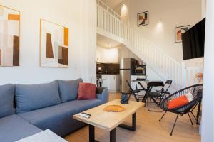 a living room with a blue couch and a table at Dreamy Seaside Loft Pool, Parking, Fast Wifi in Gouvia