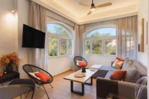 a living room with a couch and two windows at Dreamy Seaside Loft Pool, Parking, Fast Wifi in Gouvia