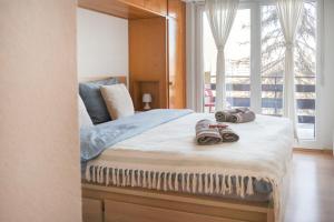 a bedroom with a bed with two slippers on it at Christiania Central Nendaz in Nendaz