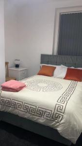 a bedroom with a large bed with red pillows at PLUS Properties Westport 2 in Stoke on Trent