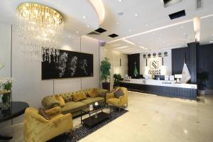 a living room with a couch and a chandelier at Friesian Hotel Apartments in Jeddah