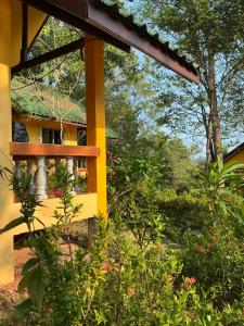 a yellow building with a balcony and some plants at elephant garden in Ban Bang Bao