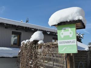 a sign in front of a house with snow on it at Villa Relax - Ferienwohnungen & Hallenbad & Relaxgarten in Bodenmais +71 photos