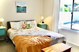 a bedroom with a bed with two tables and a window at Goolwa Blue Escape - Beach Spacious Wi-fi in Goolwa