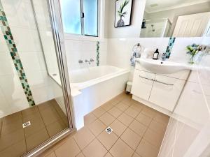 a bathroom with a tub and a sink and a shower at Goolwa Blue Escape - Beach Spacious Wi-fi in Goolwa +31 photos