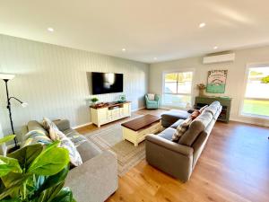 a living room with two couches and a flat screen tv at Goolwa Blue Escape - Beach Spacious Wi-fi in Goolwa