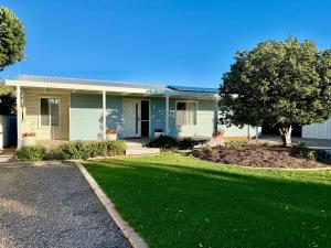 a house with a green lawn in front of it at Goolwa Blue Escape - Beach Spacious Wi-fi in Goolwa
