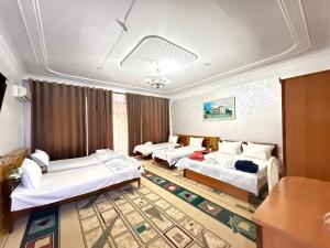a living room with three beds and a couch at BUKHARA Air Hostel in Bukhara