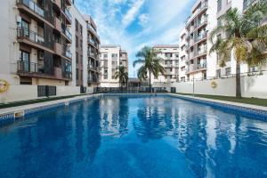 a large swimming pool in the middle of two buildings at Apartamento Mairena in Mairena del Aljarafe