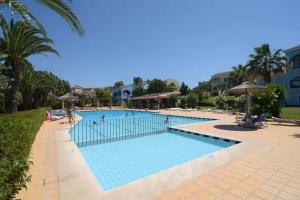 a swimming pool at a resort with people in it at Dreamy Seaside Loft Pool, Parking, Fast Wifi in Gouvia