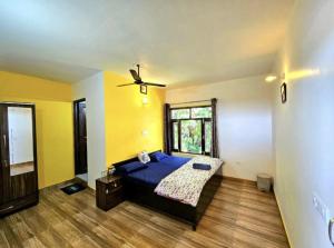 a bedroom with a blue bed and a window at Kolaveri Homes in Bīr
