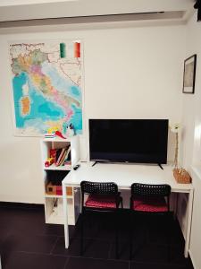 a computer desk with a monitor and two chairs at Italia House in Fót