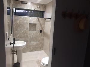 a bathroom with a shower and a toilet and a sink at 9 at Sea in Great Brak River