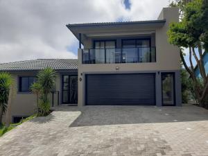 a house with a garage door in front of it at 9 at Sea in Great Brak River