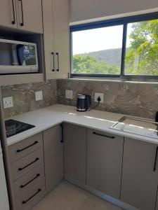 a small kitchen with a counter and a window at 9 at Sea in Great Brak River