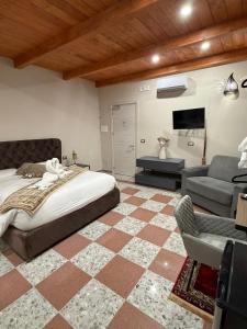 a bedroom with a bed and a couch and a tv at Villa Nunziante Grand Estate, Pompei in Scafati