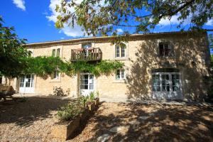 an old stone house with a balcony on it at Domaine de Beaufort in Saint-Front-de-Pradoux
