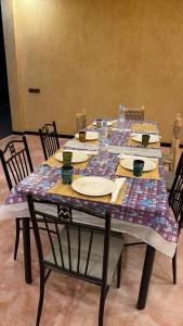 a table with plates and glasses on top of it at dar olivegarden inn in Aït Ouahi +21 photos