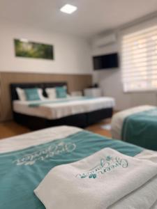 two beds in a room with two beds at Hotel Green Garden in Bucharest