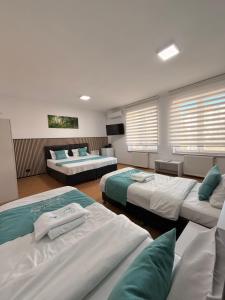 a bedroom with three beds and a couch at Hotel Green Garden in Bucharest