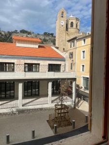 a view from a window of a building with a clock tower at Appartement avec mini suite vue Cathédrale in Cavaillon