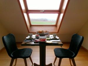 a table with two chairs and a window at b&b Kraaiberg in Ploegsteert