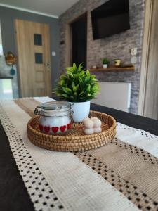 a basket with eggs and a plant on a table at Chatka Bartka in Komarówka