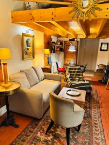 a living room with a couch and a table at Le petit Chapitre in Pinterville