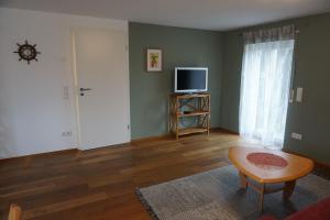 a living room with a television and a table and a door at Auszeit in Limbach