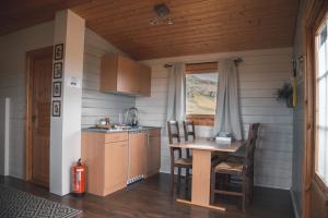 a small kitchen with a table and chairs in a room at Guesthouse Skálafell in Skálafell