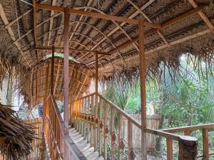 a building with a thatched roof and a staircase at Matara Eco Friendly Treehouse in Matara