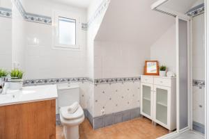 a bathroom with a toilet and a sink at Villa Sea Garden Holidays by 3VILLAS in Port d'Addaia