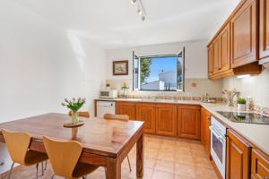 a kitchen with wooden cabinets and a wooden table at Villa Sea Garden Holidays by 3VILLAS in Port d'Addaia