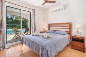 a bedroom with a bed and a balcony at Villa Sea Garden Holidays by 3VILLAS in Port d'Addaia