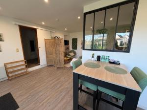 a kitchen with a table and chairs in a room at Studio ambiance ZEN in Riantec