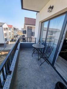 a patio with a table and chairs on a balcony at Dream Home in Giroc