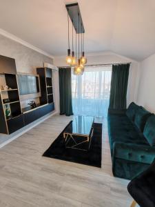 a living room with a green couch and a glass table at Dream Home in Giroc