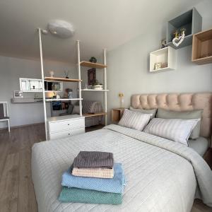 a bedroom with a large bed with towels on it at LIUxSAU apartmentai in Mažeikiai