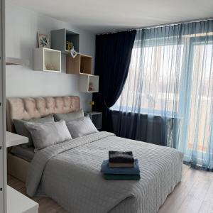 a bedroom with a large bed and a large window at LIUxSAU apartmentai in Mažeikiai