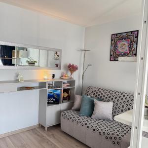 a small room with a couch and a desk at LIUxSAU apartmentai in Mažeikiai +25 photos