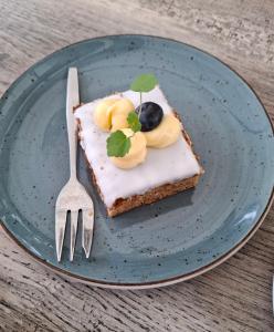 a piece of cake on a blue plate with a fork at CHALET36 in GROU in Grou