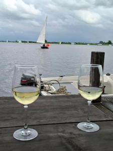 two glasses of white wine sitting on a table with a boat at CHALET36 in GROU in Grou +29 photos