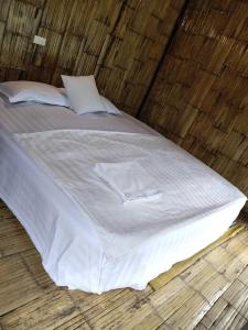 a large white bed in a wooden room at Puluongholiday homestay2 in Làng Chiêu