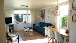 a living room with a blue couch and a table at CHALET36 in GROU in Grou