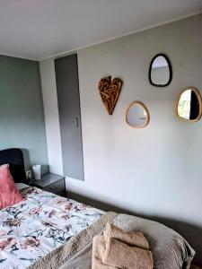 a bedroom with a bed and two mirrors on the wall at CHALET36 in GROU in Grou