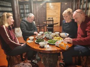 a group of people sitting around a table eating food at SaPa Hmong Streamside Homestay in Sapa