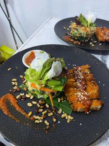 two black plates with food on a table at Adisamasta Guesthouse in Sidemen +19 photos